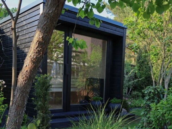 Moderne Außensauna INA Seitenansicht im Garten mit Glasfront